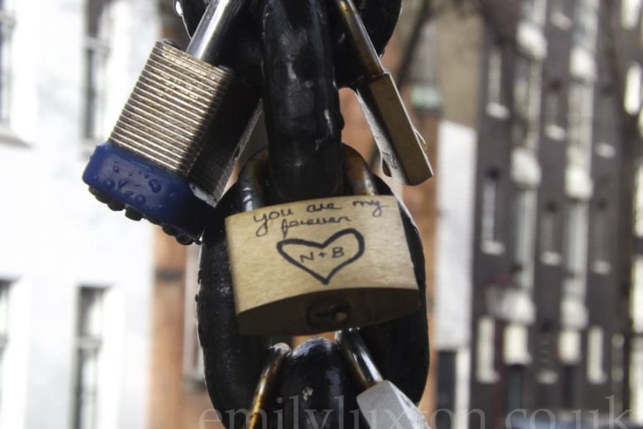 Close up pf three padlocks hanging from a thick metal chain on the Love Locks bridge in Amsterdam - the padlock at the front reads "you are my forever" with n+b written in a heart.