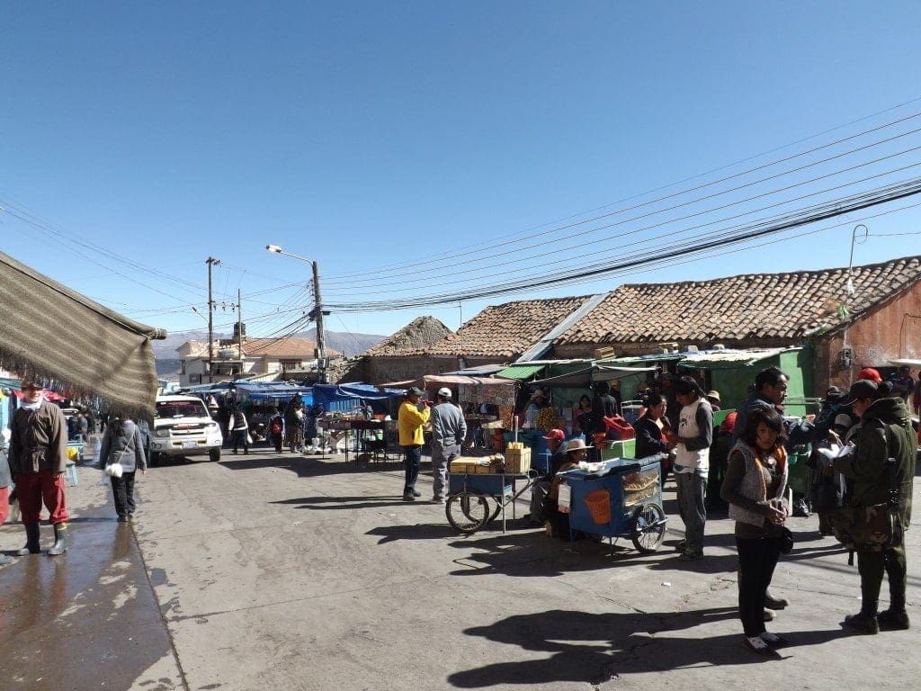 Marketplace in Potosi with several stalls under wooden covers on a sunny day with clear blue sky above