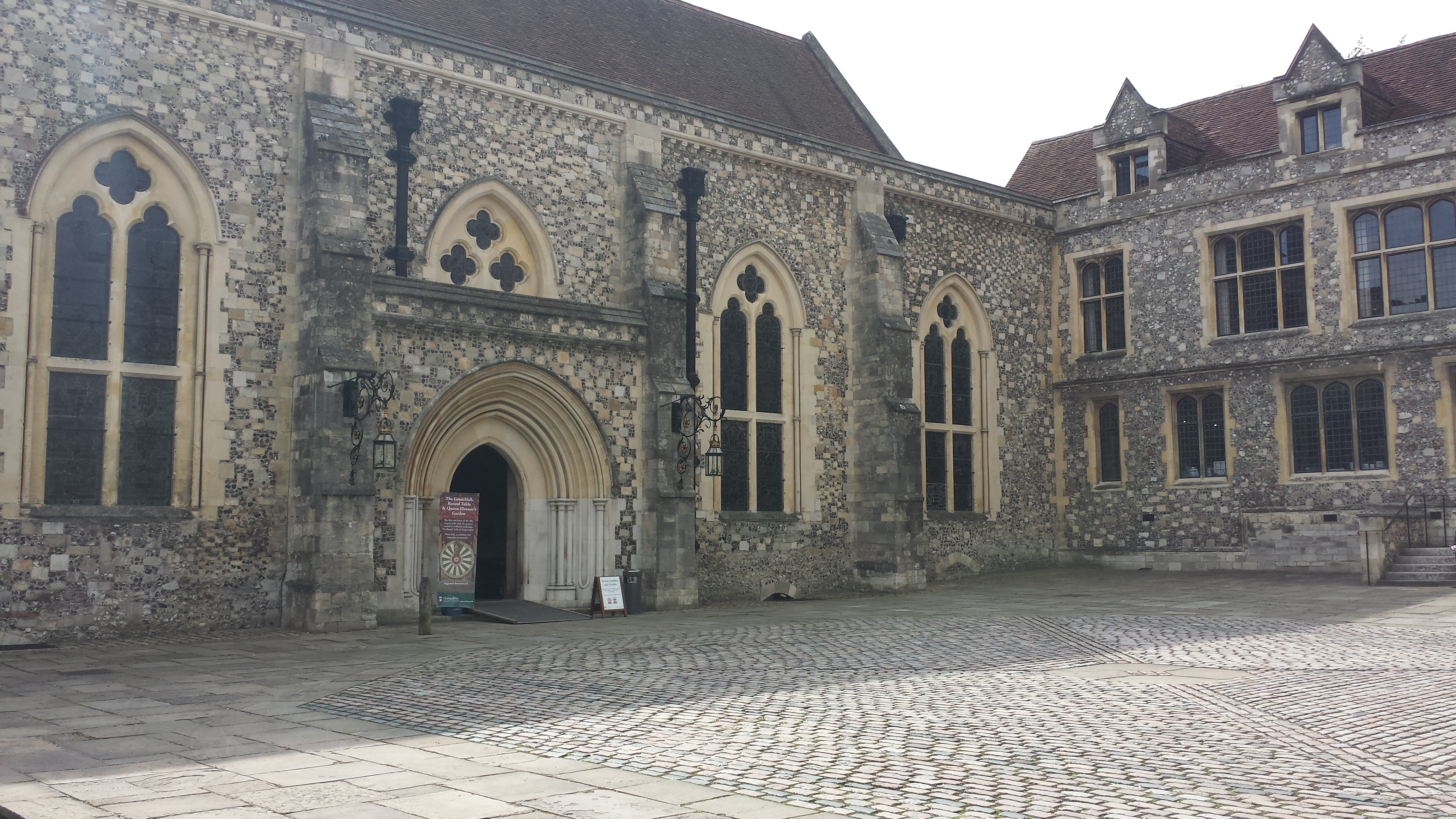 exterior of the Great Hall in winchester, a grey stone norman building with arched windows
