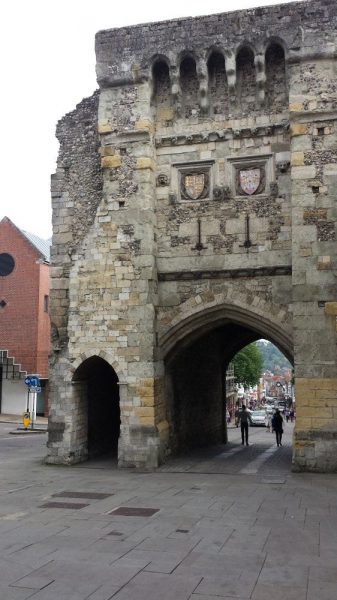 partly ruined stone gatehouse building with an open archway through whch you can see a town high street