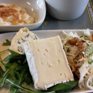 Close up of two pieces of cheese on a bed of rocket on a white china plate. Meal on board Eurostar Standard Premier.