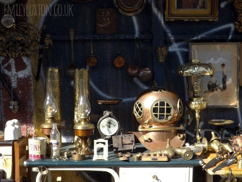 Antiques on a stall at the Athens flea market, various items of bric a brac including a large copper diving helmet