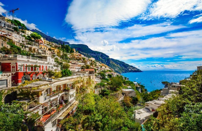 colourful town on the side of a cliff overlooking blue sea in italy 
