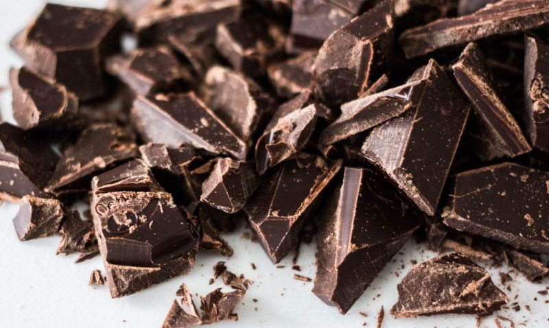 close up of chipped dark chocolate pieces on a white plate