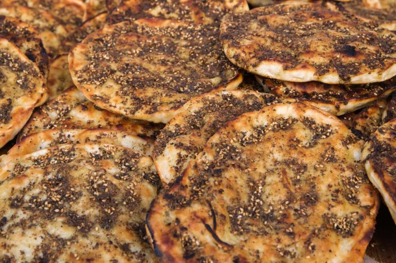 close up of many circular flatbreads topped with herbs. what to eat in dubai
