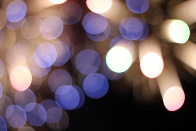Out of focus boke effect of blue and white fireworks in the night sky at Edinburgh Hogmanay