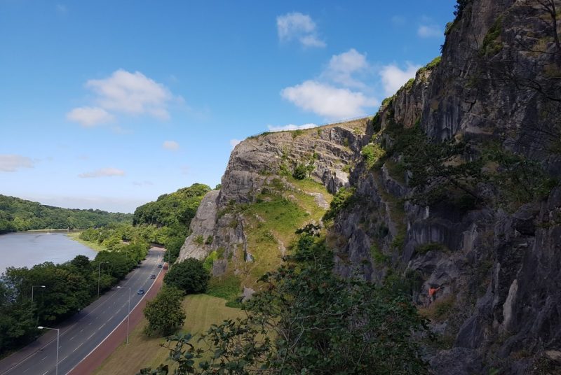 grey rocky cliffs beside a wide road running next to a river at Avon Gorge Bristol