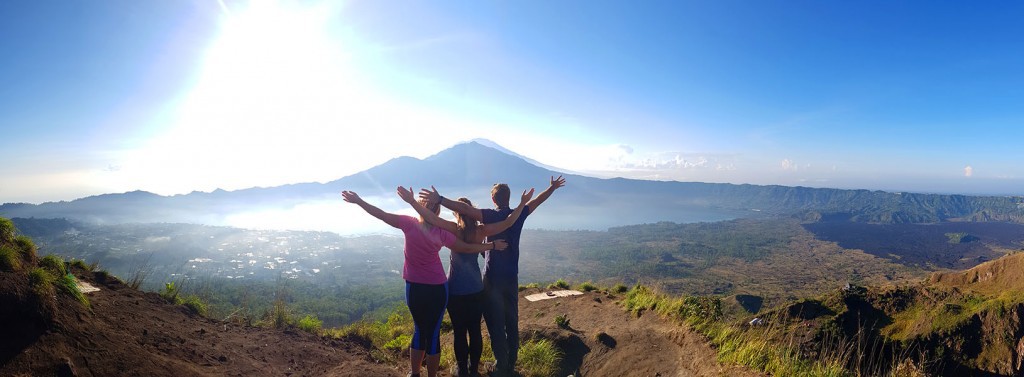 panorama showing three people at the top of a mountain