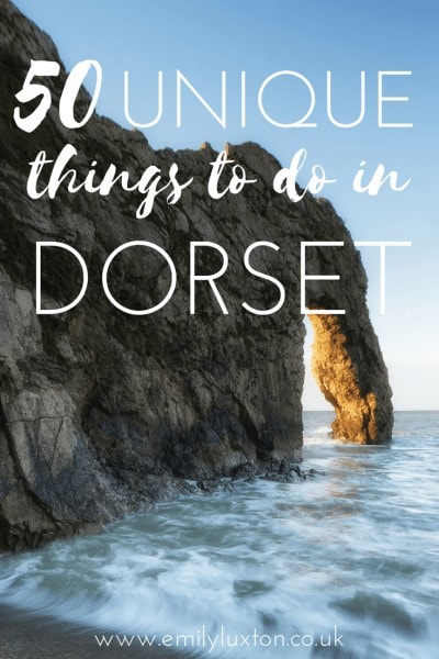 Photo of a large rock archway over the sea on a sunny day with blue sky. The text over the top reads: 50 Unique things to do in Dorset