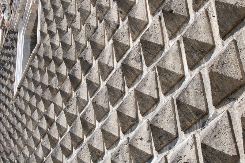 Outside wall of a church covered with square shaped stone cones