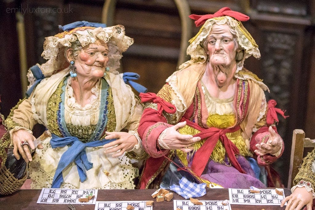 Close up of two Nativity Figures depicting two elderly women in frilly bonnets and old fashioned dresses with lace aprons 