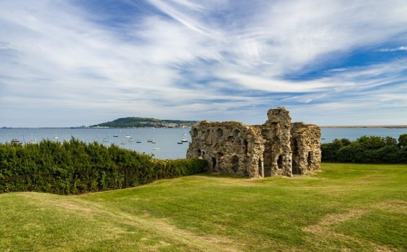 Sandsfoot Castle in Weymouth, a small stone castle in ruins on the edge of a cliff with the sea behind and the isle of portland visible across the bay