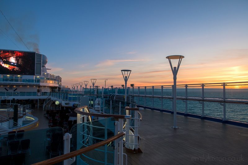 Big screen playing a movie outdoors on a ship deck at sunset - entertainment on the Regal Princess from Princess Cruises