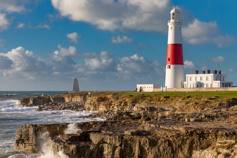 Red and white lighthouse on a cliff edge at Portland Bill