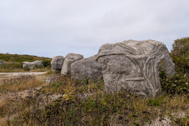 Large grey rock with a swirled design carved into it at Tout Quarry Sculpture Park