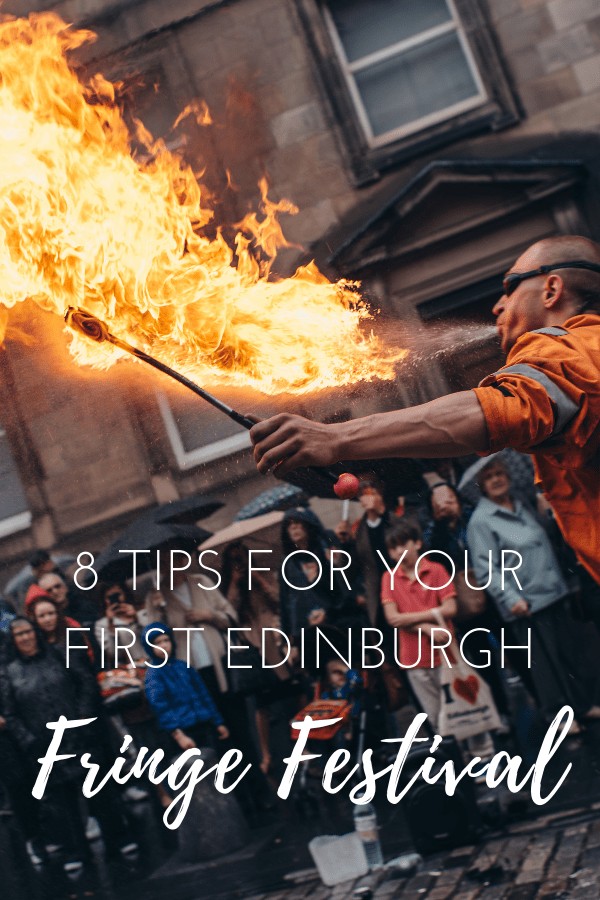 Man dressed in an orange jumpsuit breathing fire in front of a crowd of people watching. The text over the top of the photo reads: 8 tips for your first Edinburgh Fringe Festival