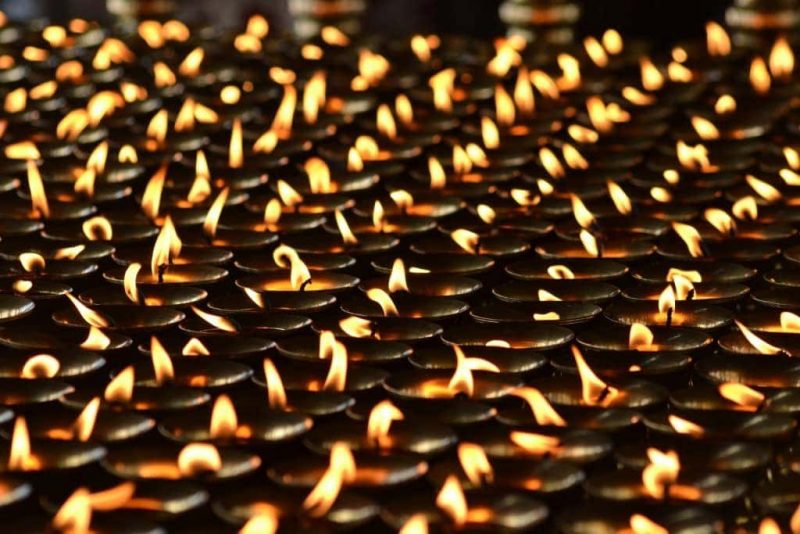 close up of hundreds of small black candles with small flames at a Diwali celebration in India