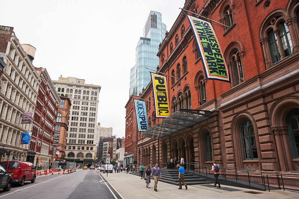 a street in new york city on a grey day with the large red brick building of the Public theatre on the right - cool things to do in NYC.