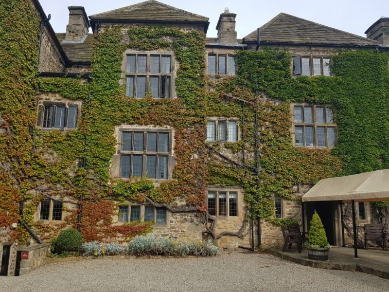 Exterior of a large country manor hotel in Durham built from beige coloured stone with three floors covered in ivy.