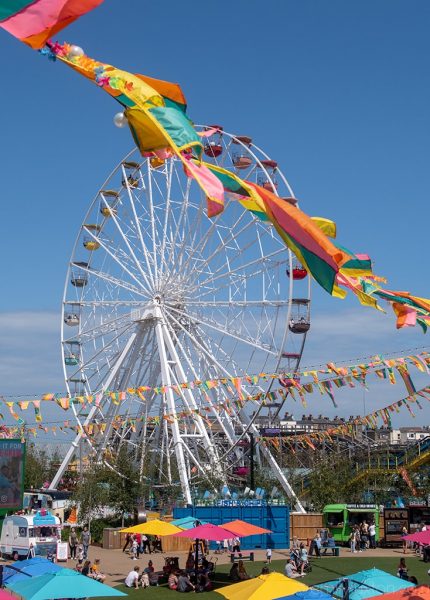 Big Wheel at a Seaside Funfair with Colourful Flags in Foreground