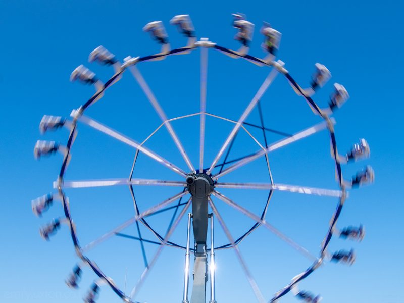 Spinning ride against blue sky