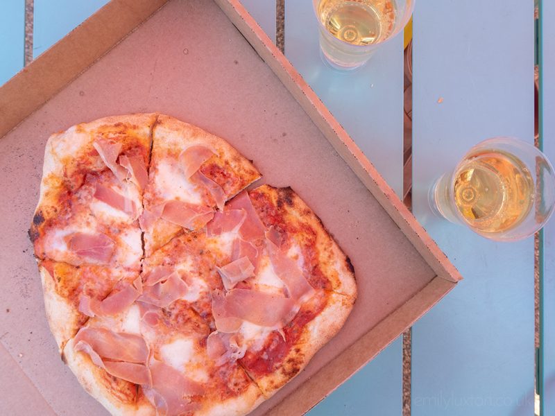 Flat lay of pizza and prosecco on a table