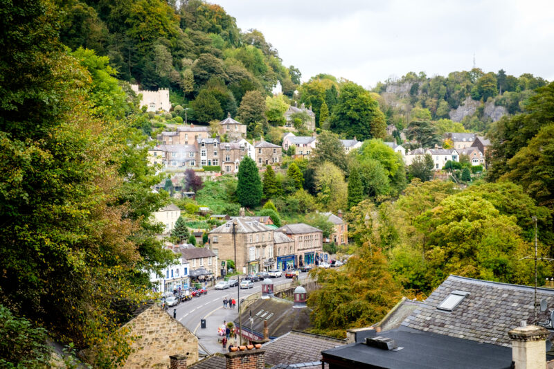 View of Matlock Bath town with stone cottages on a forested hillside