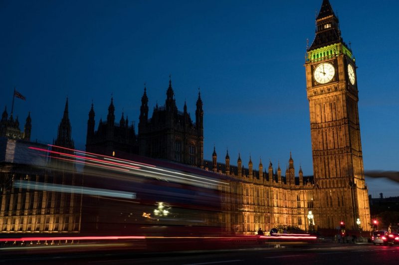 Big ben at night lit up against a black sky