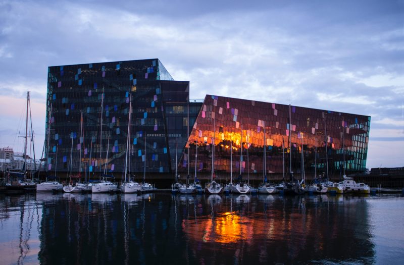 modern glass building at nigt reflected in a harbour