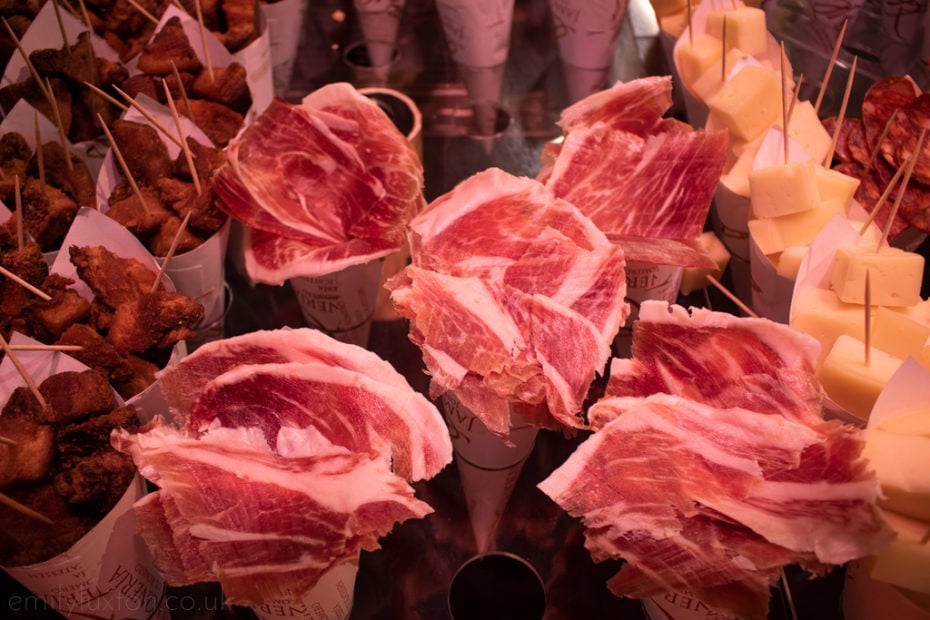 Cones of jamon iberico in a row in a market in Seville