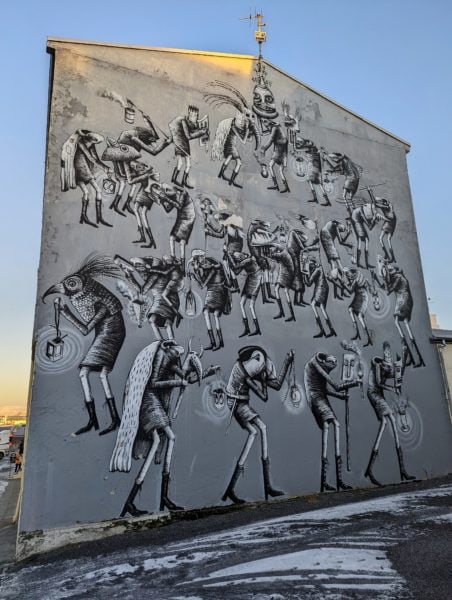 a large mural of black and white stick figures on the side of a building