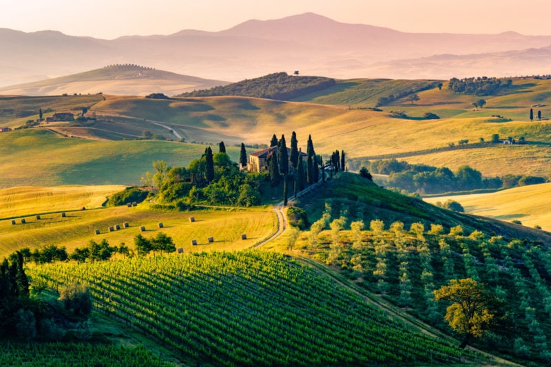 aerial view of a farmhouse surrounded by cypress trees on a hill in tuscany italy, a popular setting for walking holidays