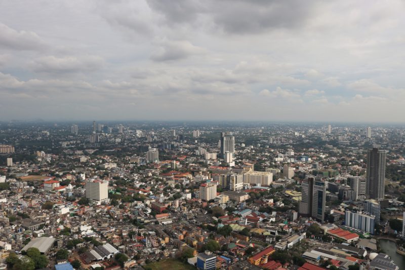 looking across a city with lots of skyscrapers on a grey day with a cloudy sky above - visiting colombo on a 2 weeks sri lanka itinerary