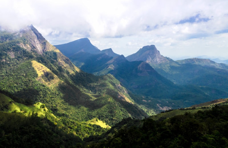 view of green mountains disappearing into mist above a forested valley in Sri Lanka 