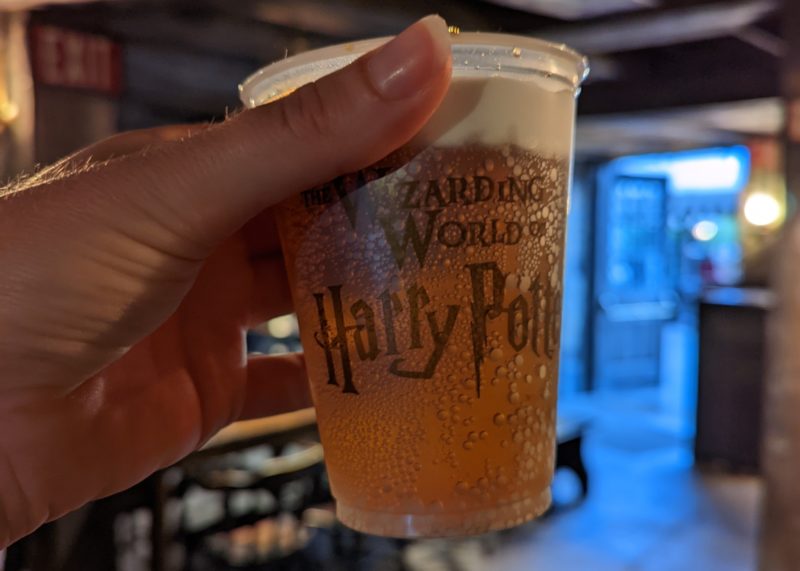 close up of a plastic cup of Butterbeer with a cream foam on the top at the Wizarding World of Harry Potter in Universal Orlando 