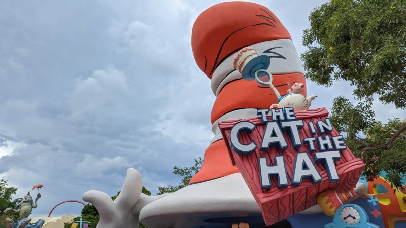 giant red and white striped hat with a saign saying The Cat in the Hat with a cloudy sky behind. budget guide to universal studios in orlando florida