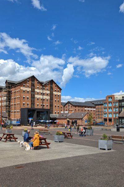 National Waterways Musuem by the docks in Gloucester - a large red brick warehouse building under a blue sky. Gloucester and Cheltenham weekend itinerary. 