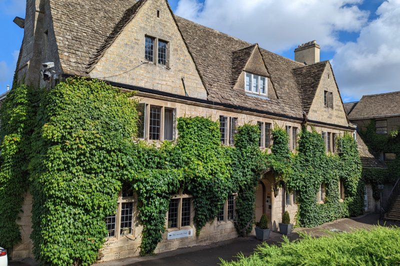 large country house built from grey stone covered in green ivy with a dark grey tiled rook - hatton court hotel gloucestershire