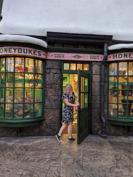 emily in a black and white dress going through a shop doorway into Honeydukes at Universal Islands of Adventure