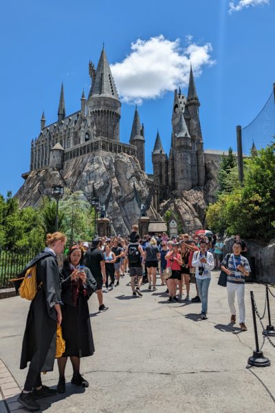 large crowd in front of Hogwarts Castle at Universal Florida on a very sunny day