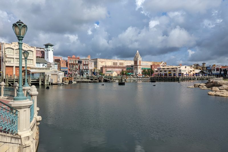 looking across a lake towards various pretend buildings at Universal Orlando on a cloudy day 