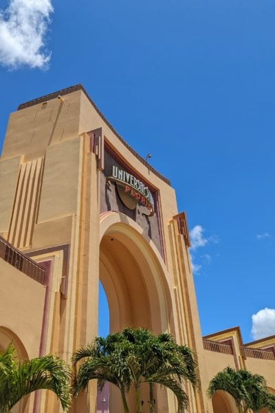 Yellow archway with a sign saying Universal Studios Florida against a blue sky at the entrance to the park 