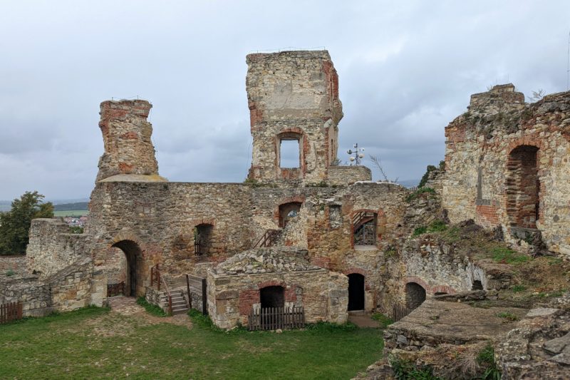 ruined castle walls built from grey stone and red brick against a grey sky. Best day trips from Brno. 