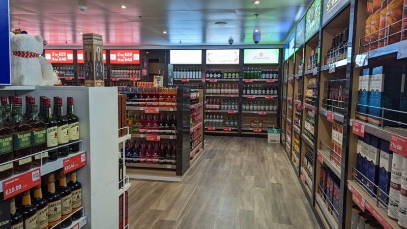 a shop with faux wooden laminate flooring and many shelves lined with different alcohol bottles