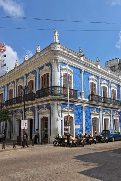 two storey colonial style building covered with bright blue tiles with white trim around the windows and roof, on a very sunny day with blue sky overhead - best things to do in villahermosa mexico
