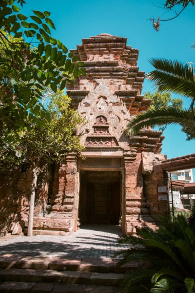 a beige stone temple structure with carved facade and a dark entryway leading indside. best day trips from malaga.