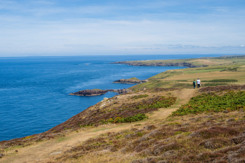 Two people walking on the the Wales Coast Path near to Aberdaron on the Llyn Peninsula, a designated long-distance trail which follows, or runs close to, the coastline of Wales