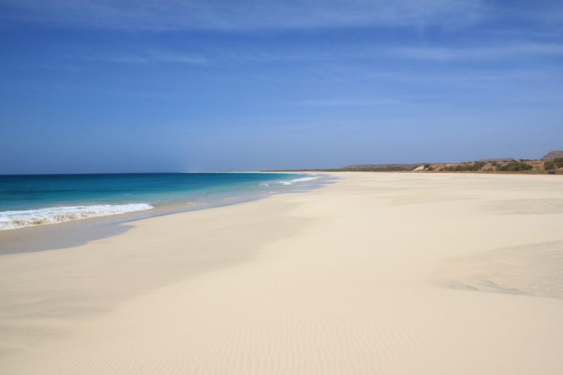 empty beach with white sand and very blue sea under a blue sky