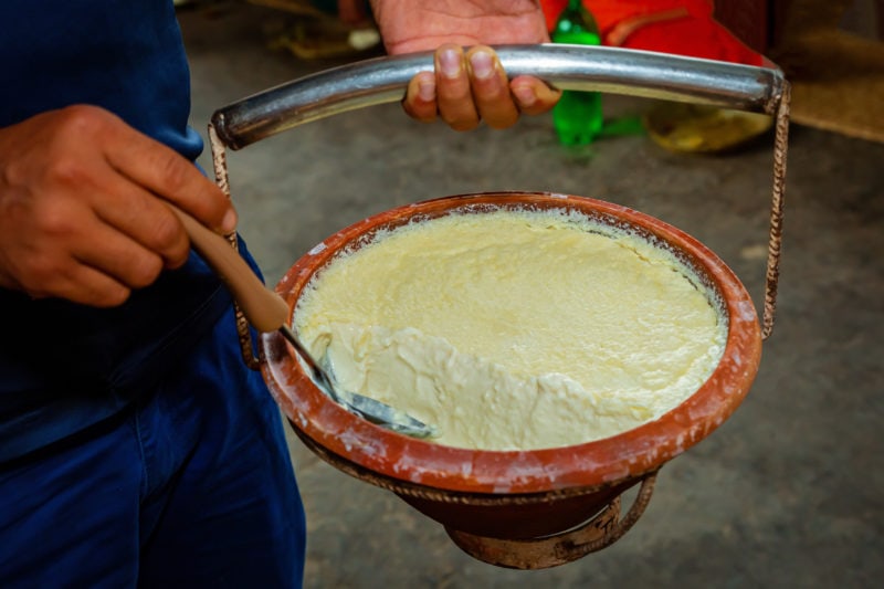 Close up of Plain Curd in a clay pot with holding hands. Dahi or Yogurt in Kathmandu Nepal. 