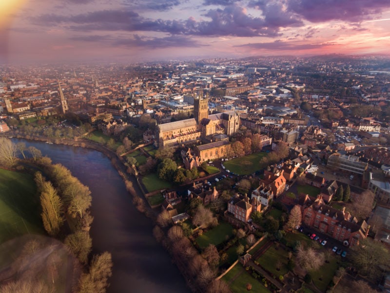 aerial view of Worcester city and a wide river at sunset with pink sky. Most beautiful cities in England. 